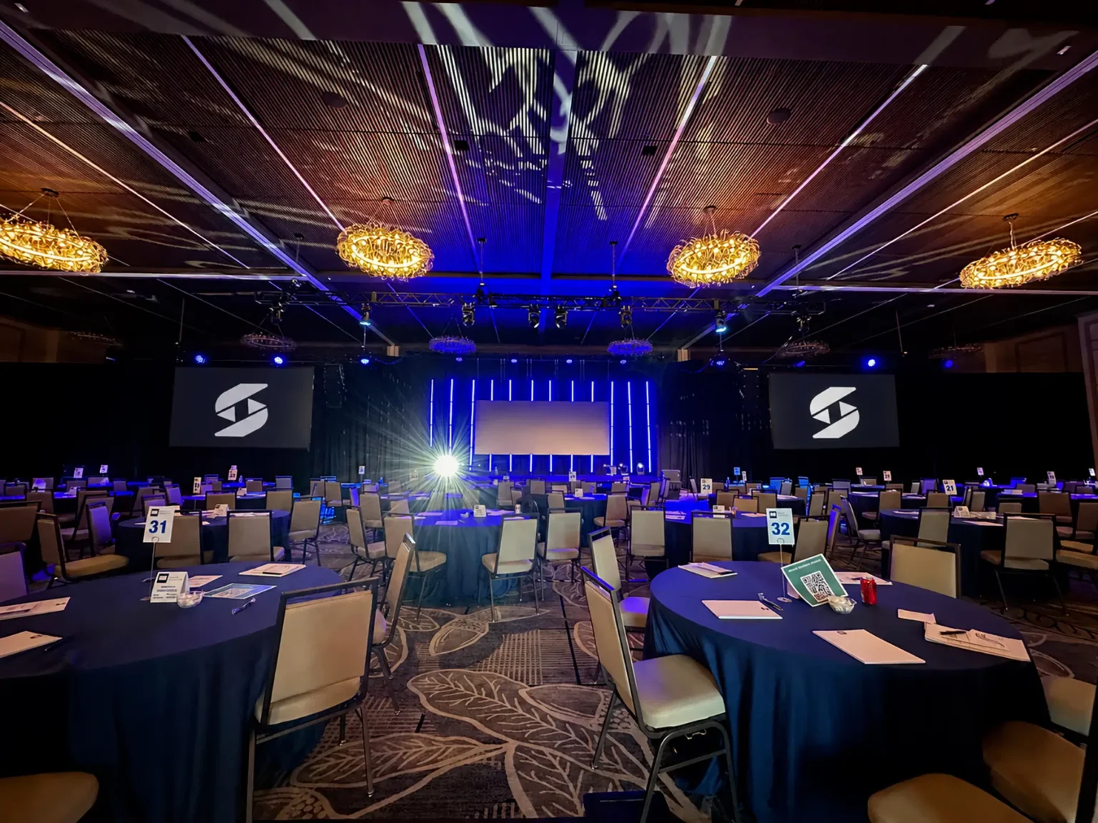 Conference ballroom setup at Omni PGA Frisco prepared for a corporate event with staging and AV.